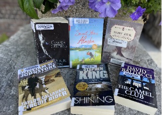 Paperback books in front of a flowerpot